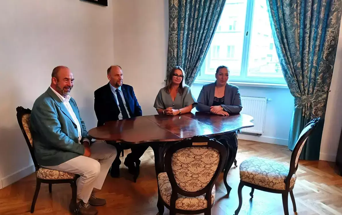 Przy stole na zabytkowych krzesłach siedzą przedstawiciele powiatu wodzisławskiego, miasta i muzeum. 