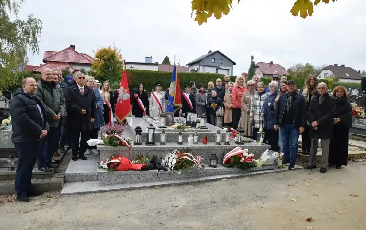 ludzie stojący nad grobem
