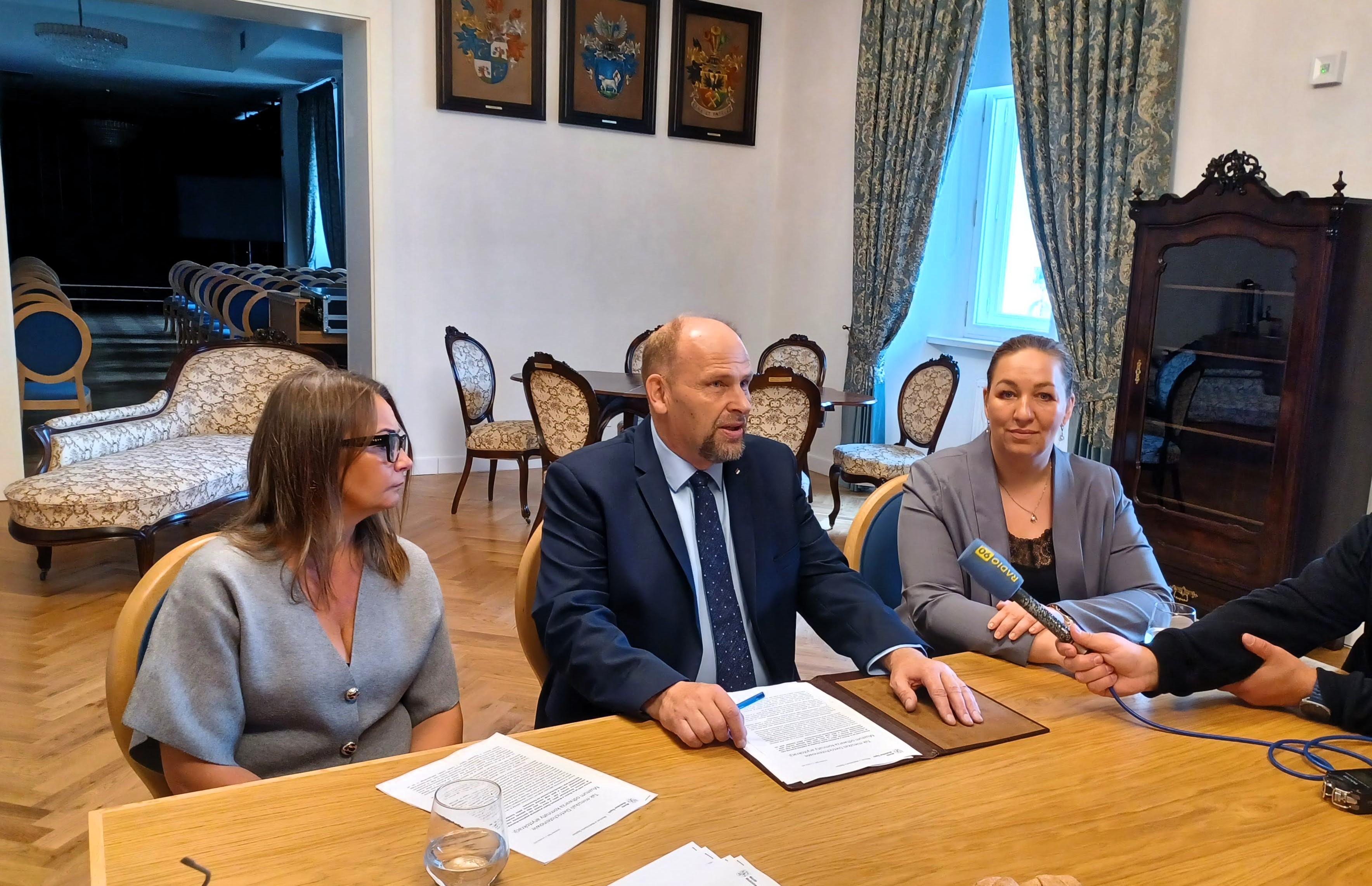 trzy osoby siedzące przy stole