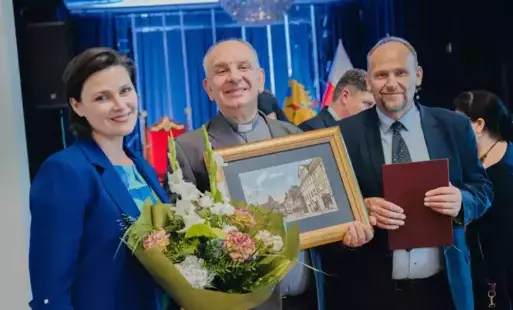Kobieta i dwóch mężczyzn pozują do zdjęcia z obrazem