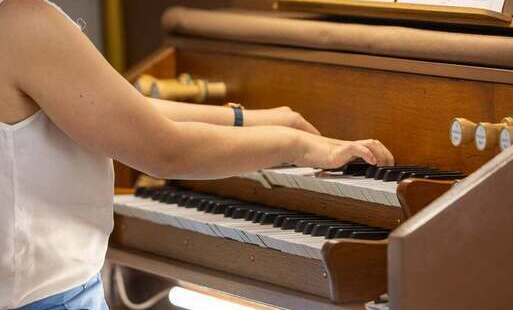 Kobieta grająca na organach. Ujęcie boczne. 